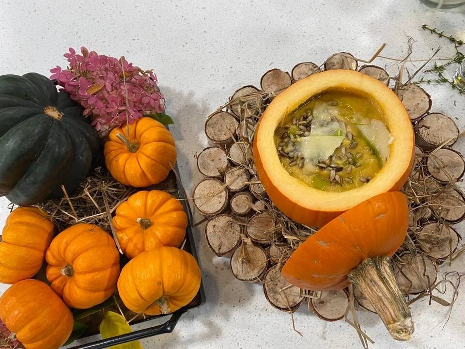 Potage de courge poivrée au miel, tournesol rôti, copeaux de fromage cheddar âgé servi dans une petite citrouille 