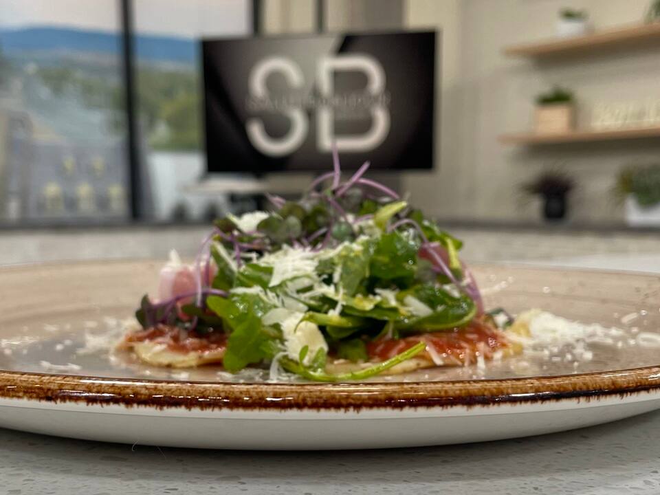 Pizza de patates avec huile, miel, roquette et prosciutto